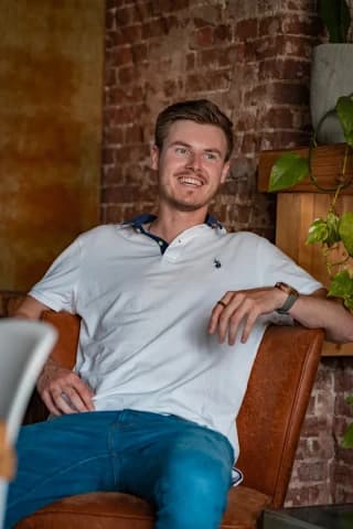 Jongeman op stoel in cafe tijdens tindershoot