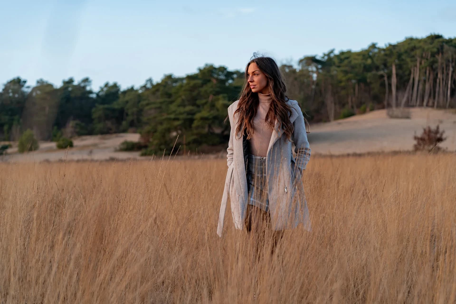 Jonge vrouw lopend over heide tijdens datingshoot voor bumble in loonse en drunense duinen
